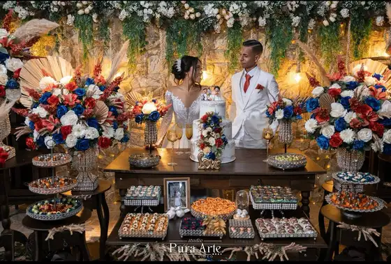 Noivos atrás da mesa de doces decorada